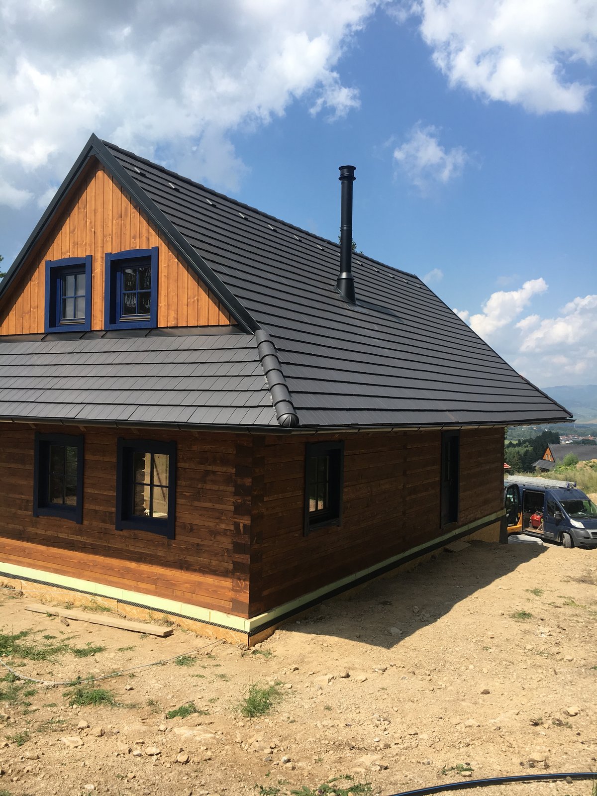 Realizácia: moderný čierny rodinný dom s nerezovým komínom